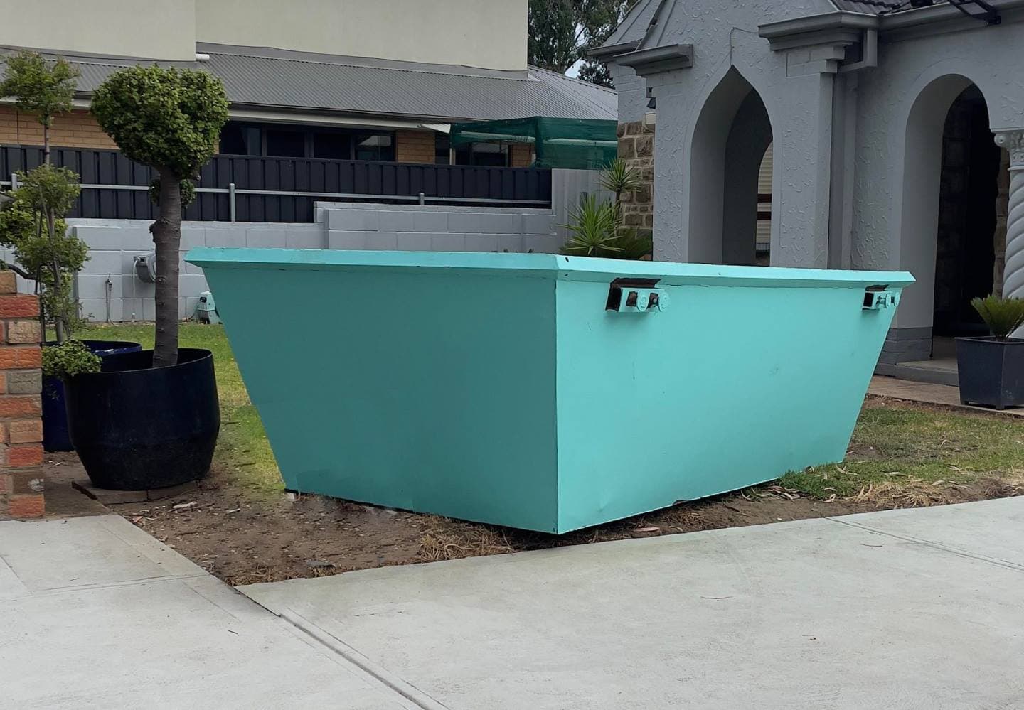 4 cubic meter turquoise skip bin hire Adelaide - medium sized waste bin on residential driveway for kitchen renovations and shed cleanouts